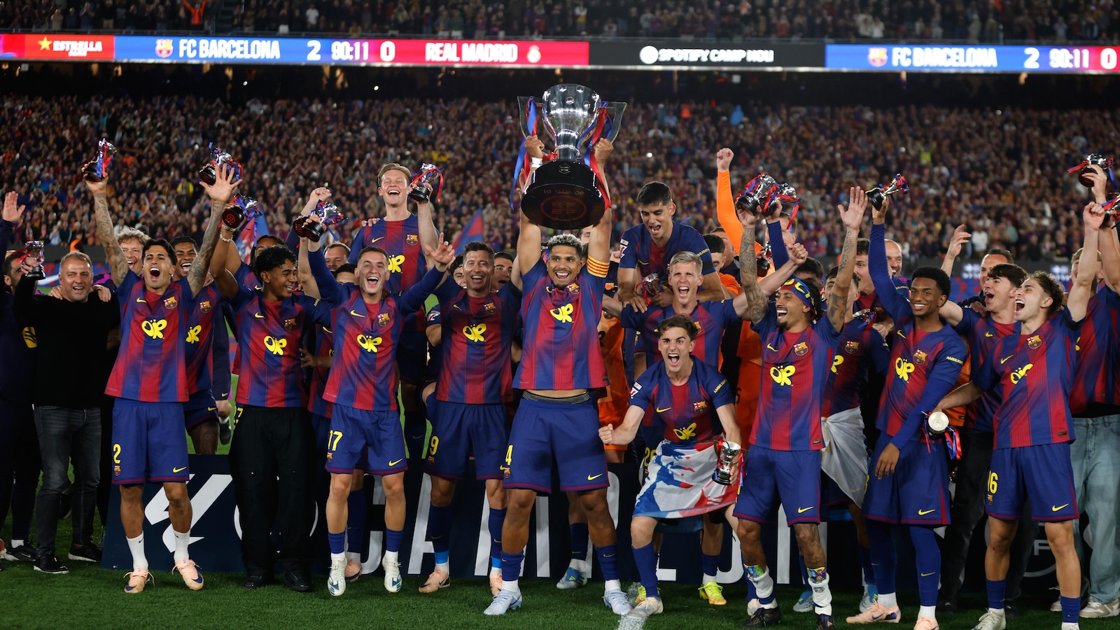 Watched by its grieving coach, Barcelona retains Spanish league title by beating rival Real Madrid